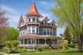 a queen anne home with a widows walk and turret