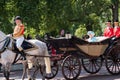 Queen Elizabeth II travels along The Mall in an open carriage pulled by horses, on her way to the Trooping of the Colour parade.