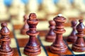 Queen and King in the foreground. Color photo of chess Board and chess pieces, wooden chess pieces on the chessboard Royalty Free Stock Photo