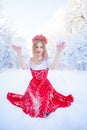 Queen in a red crown among the winter forest. Lovely girl in a