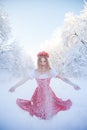 Queen in a red crown among the winter forest. Lovely girl in a