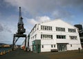 Redevelopment of seashore with refurbished gray historic crane and renovated storehouse on Queens Wharf, Wellington, New Zealand