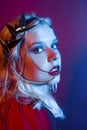 Queen in a silver crown, trendy stylish neon photo. The woman is all in jewelry and bijouterie. Red blue light. Evening make-up,