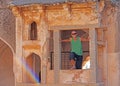 Queens Bath in Hampi. A bald tourist man stands surrounded by a