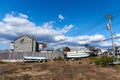 Two small motorboats on trailers are parked in front of and abandoned house in Broad Channel, Queens, NY Royalty Free Stock Photo