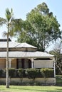 Queenslander with white lattice and tall palm tree in front