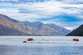 Queenstown New Zealand - April 19 2022; tourist jet-boats and Shark on Lake Wakatipu with Remarkables Mountain Range background Royalty Free Stock Photo