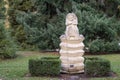 Fleur by Elizabeth Hall, 2001. Stone statue of a woman sitting on top of stack of pillows