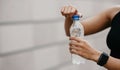 Quench thirst. African american young woman with smart watch opens water bottle