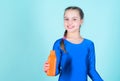 Quench thirst. Child feel thirst after sport training. Kid cute girl gymnast sports leotard hold bottle for drink. Water Royalty Free Stock Photo