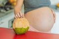 Quenching her pregnancy thirst with a refreshing choice, a pregnant woman joyfully drinks coconut water from a coconut Royalty Free Stock Photo