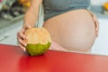 Quenching her pregnancy thirst with a refreshing choice, a pregnant woman joyfully drinks coconut water from a coconut Royalty Free Stock Photo