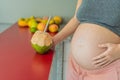 Quenching her pregnancy thirst with a refreshing choice, a pregnant woman joyfully drinks coconut water from a coconut Royalty Free Stock Photo