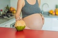 Quenching her pregnancy thirst with a refreshing choice, a pregnant woman joyfully drinks coconut water from a coconut Royalty Free Stock Photo