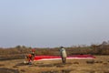 tandem paragliders with red parachutes and helmets prepare to take off against the background of dry