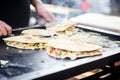 quesadillas being toasted on a griddle