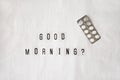 Question Good morning, pills in blister pack on crumpled white sheet. Awakening concept with headache, fever, medicine, illness,