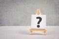 Question mark on an easel, education and business concept, searching for answers, thoughts for solving a problem, having doubts Royalty Free Stock Photo