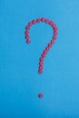 Question mark made from red medicine pills on blue background Royalty Free Stock Photo