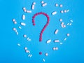 Question mark made from red medicine pills on blue background Royalty Free Stock Photo