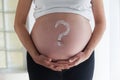 Question mark painted with body cream on pregnant woman`s belly Royalty Free Stock Photo