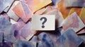 Question mark on paper card with colorful torn paper background, symbolizing curiosity and uncertainty in creative concept Royalty Free Stock Photo