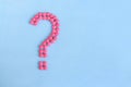Question mark from pink pills on blue background Royalty Free Stock Photo
