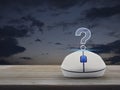 Question mark sign icon with wireless computer mouse on wooden table over sunset sky, Business customer support concept Royalty Free Stock Photo