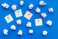 Question mark on sticky notes near crumpled paper on blue background top view Royalty Free Stock Photo