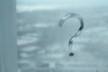 Question mark on a wet window pane, concept of questionnaires Royalty Free Stock Photo