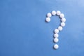 Question mark white pills on blue background. Royalty Free Stock Photo