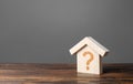 Question mark on a wooden house. Cost estimate. Solving housing problems, deciding to buy or rent real estate. Search for options Royalty Free Stock Photo