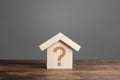 Question mark on a wooden house. Solving housing problems, deciding to buy or rent real estate. Search for options Royalty Free Stock Photo