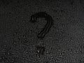 Question mark written on a surface made of drops on a black background Royalty Free Stock Photo