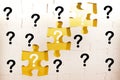 question marks and white jigsaw puzzle pieces on a yellow background. FAQ, Business solution concept Royalty Free Stock Photo