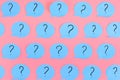 Question marks are written on blue stickers in the form of a bubble. Blue paper pasted on a pink background. Bright