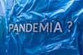 The question pandemia translation from spanish - pandemic laid with silver letters on crumpled blue plastic film