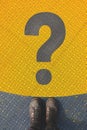 Questioning and reflective personality concept, man standing over large question mark symbol on non slip plastic flooring