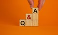 Questions and answers symbol. Concept word `Q and A` on cubes on a beautiful orange background. Male hand. Business, questions a Royalty Free Stock Photo