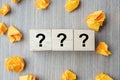 Questions Mark  ?  word with wooden cube block and yellow crumbled paper on table background. FAQ frequency asked questions, Royalty Free Stock Photo