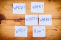 Questions - Why? What? Where? When? Why? How? on blue stickers on wooden background. Business, text, communication, information, m Royalty Free Stock Photo