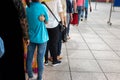 Queue of Asian people wait in line in urban street