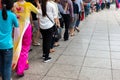 Queue of Asian people wait in line in urban street Royalty Free Stock Photo