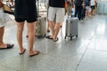 Queue of Asian people waiting at boarding gate at airport. Close-up composition