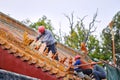 Workers repairing roof figure decorations and architectural details at the Temple of Confucius in Qufu, China Royalty Free Stock Photo