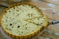 Quiche pie Lorraine with sliced slice on a wooden table