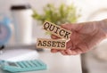 Quick Assets Word Written on Wooden Block in Hand With Cap Coffee and Calculator Royalty Free Stock Photo