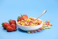 Quick breakfast cereal - rings with milk and strawberries on a blue background. Royalty Free Stock Photo
