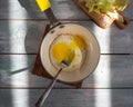 Quick breakfast with one egg egg in a small frying pan with a yellow handle, sliced Chinese cabbage