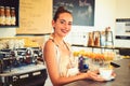 A quick cup to start a hectic workday morning. Pretty woman stand behind cafe counter. Brewing coffee in coffeehouse Royalty Free Stock Photo